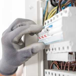 Electrician Testing Fuses In the Electric Box